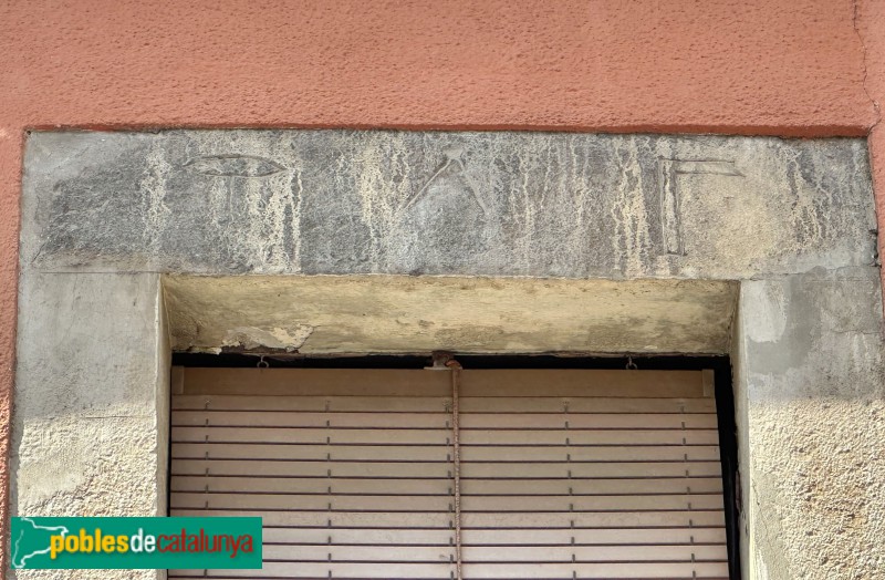 Sarrià de Ter - Llinda amb símbols d'ofici